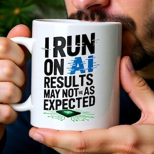 Op de afbeelding: Witte keramische mok met de tekst "I RUN ON AI RESULTS MAY NOT BE AS EXPECTED" in zwart en blauw. Onderaan staat een groene printplaat. De mok heeft een wit handvat.