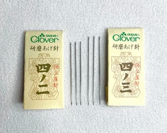 Op de afbeelding: Twee pakjes Clover-naalden voor het naaien van kimono's. Elk pakje bevat zes naalden en heeft de tekst "研磨あげ針" en "四ノ三" erop gedrukt.