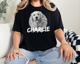 May include: Black t-shirt with a white circle graphic featuring a black and white photo of a golden retriever dog. The text "CHARLIE" is printed in white below the circle.