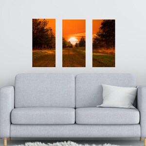 May include: A three-piece sunset landscape wall art print set featuring a path leading through a forest towards a bright orange sunset.
