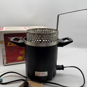 May include: Black electric deep fryer with a silver perforated basket and a handle. The fryer has a black body with a silver rim and a handle. The cord is black. The box is red and white with the text "ELECTRIC DEEP FRYER".