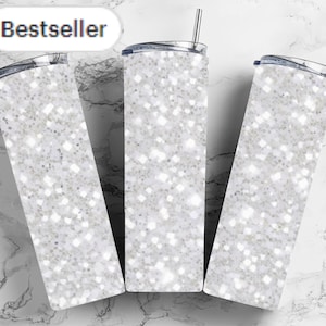 May include: Three white stainless steel tumblers with a sparkly glitter design. The tumblers have lids and straws. Bestseller is written in the top left corner of the image.