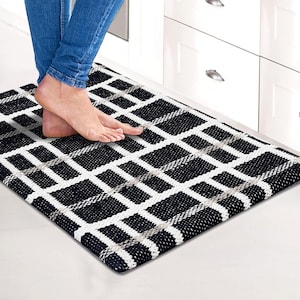 May include: Black and white checkered kitchen rug with a geometric pattern. The rug is made of a soft, comfortable material and is perfect for adding a touch of style to any kitchen.