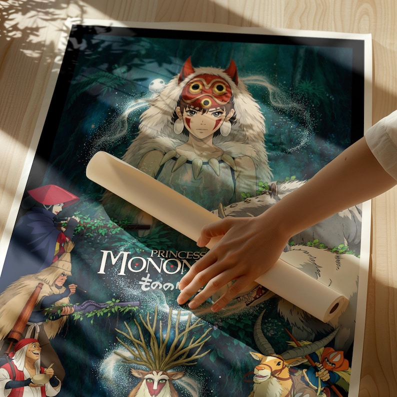 K&ouml;nnte beinhalten: Eine gerollte Poster mit einer farbenfrohen Illustration aus dem Animationsfilm "Prinzessin Mononoke". Das Kunstwerk zeigt eine Frau mit einer Maske, umgeben von Waldlandschaft und Charakteren. Das Poster wird von einer Person gehalten.