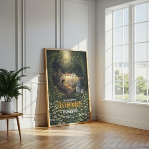K&ouml;nnte beinhalten: Ein gerahmtes Poster des Zeichentrickfilms "Mein Nachbar Totoro". Das Kunstwerk zeigt Totoro, einen gro&szlig;en Waldgeist, mit Kindern und anderen Kreaturen in einer Waldlandschaft. Das Poster hat einen Holzrahmen und lehnt an einer wei&szlig;en Wand.