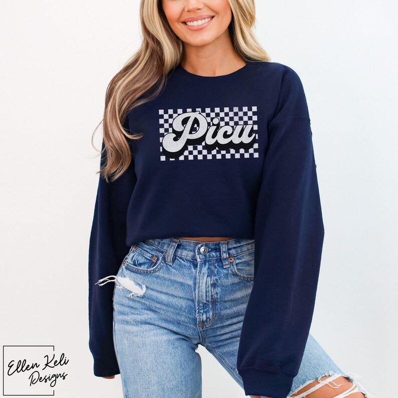 May include: A navy blue cropped sweatshirt with a white checkered design and the word "Picu" in a retro font.