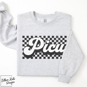 May include: A gray sweatshirt with a black and white checkered pattern and the word "Picnic" in a retro font.