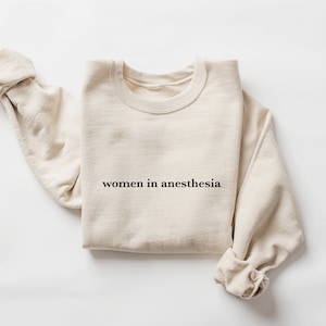 Peut inclure: Un sweat-shirt beige avec le texte "women in anesthesia" imprim&eacute; sur le devant.