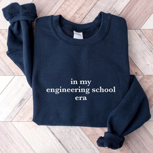 May include: A navy blue sweatshirt with the text "in my engineering school era" printed in white on the front.