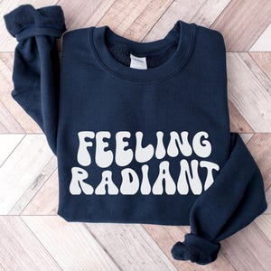 a black sweatshirt with the words feeling radiant printed on it