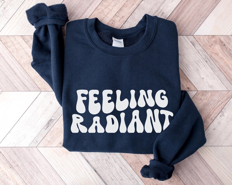 a black sweatshirt with the words feeling radiant printed on it