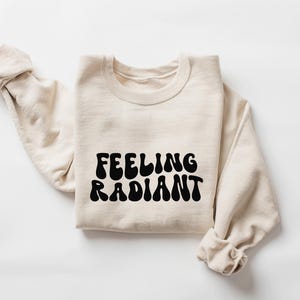 a sweater with the words feeling radiant printed on it