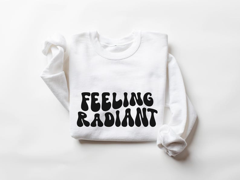 a white sweatshirt with the words feeling radiant printed on it