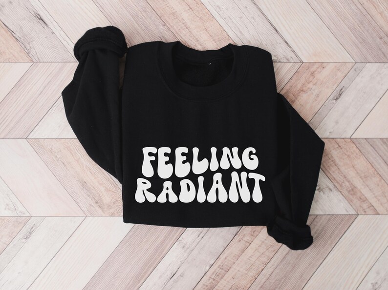 a black sweatshirt with the words feeling radiant printed on it