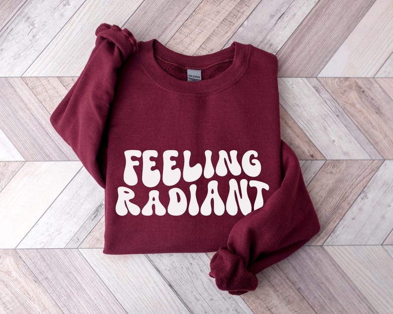 a red sweatshirt with the words feeling radant printed on it