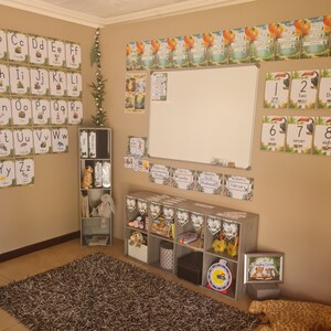 May include: A classroom decorated with a jungle theme. The walls are covered in colorful posters with letters, numbers, and days of the week. There are also shelves with books and toys. The room is bright and cheerful.