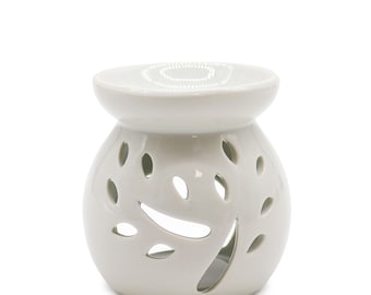 Könnte beinhalten: Weißer Keramik-Ölbrenner mit einem Blattdesign. Der Brenner hat oben eine kleine Schale zum Aufnehmen von Öl und einer Kerze.