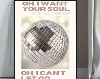 May include: A framed print featuring a disco ball with mirrored tiles. The text "OH, I WANT YOUR SOUL, DO YOU WANT IT RIGHT NOW? OH, I CAN'T LET GO" is displayed in a muted pink font. The artwork is set against a neutral background.