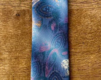 May include: A blue silk tie with a paisley pattern in shades of white, pink, and orange.