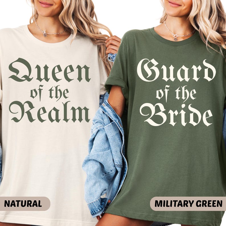 May include: Two t-shirts, one natural and one military green, with text. The natural shirt reads "Queen of the Realm" in a dark green font. The military green shirt reads "Guard of the Bride" in a white font. Both shirts are short-sleeved.