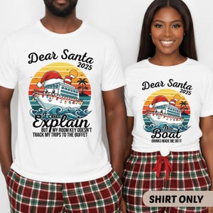 May include: White t-shirts with a colorful graphic featuring a cruise ship wearing a Santa hat, the text "Dear Santa 2025", and the phrase "I can explain but my room key doesn't track my trips to the buffet". The other shirt says "The Boat Drinks Made Me Do It".