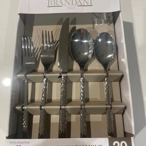 Puede incluir: Una caja de 20 piezas de cubiertos con un patrón de diamante. El juego incluye cuchillos, tenedores y cucharas. La caja es blanca con texto negro y un logotipo. El texto en la caja dice "BRANDANI ITALY HOTEL COLLECTION FLATWARE SET DIAMOND 20 pieces SET POSATE COUVERTS HIGH QUALITY STAINLESS STEEL".