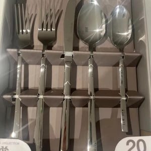 Op de afbeelding: Een set van 20 stuks zilveren bestek in een doos. De set bevat vorken, messen en lepels. De doos is wit met zwarte tekst die "20 stuks" zegt.