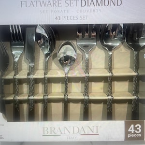 Puede incluir: Un juego de 43 cubiertos de plata en una caja blanca. El juego incluye tenedores, cuchillos y cucharas. La caja tiene las palabras "Flatware Set Diamond" y "Brandani Italy" impresas en ella.