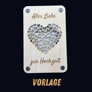 May include: A rectangular wooden plaque with the words "Alles Liebe zur Hochzeit" and "VORLAGE" engraved on it. A heart shape is cut out of the wood, filled with smaller heart shapes. The plaque has four silver magnets.