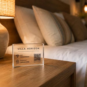 May include: A clear rectangular acrylic sign with black text and a QR code. The text reads VILLA HORIZON, WiFi HorizonGuest, and Password Summer2026. Below the QR code, the text reads SCAN TO CONNECT. The sign is positioned on a wooden surface.