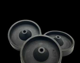 May include: Three black rubber bottle stoppers with a cone-shaped center and the text "100%" on one of the stoppers.