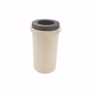 Op de afbeelding: Een cilindrische smeltkroes met een lichtbeige, getextureerd keramisch lichaam met een brede rand en een contrasterend donkergrijs, rond deksel dat vlak in de bovenste opening ligt. De houder heeft een recht ontwerp met een matte afwerking.