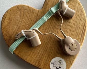 Pastel green non slip hearing implant headband with colorless sliders and with rubber loops