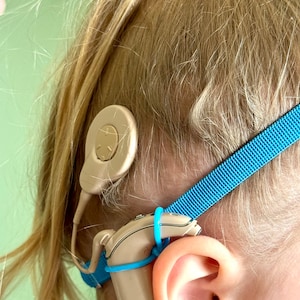 Blue non slip hearing implant headband with colorless sliders and rubber loops