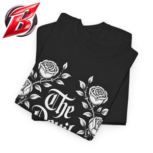 Puede incluir: Camisetas negras con un diseño floral blanco de rosas y el texto "The Devil". Las camisetas están dobladas y apiladas. Un logotipo está en la esquina superior izquierda.