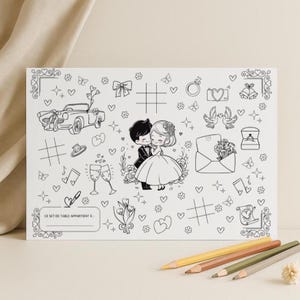 Peut inclure: Une feuille à colorier blanche sur le thème du mariage avec des dessins au trait noirs. Le motif comprend une mariée et un marié, une voiture classique, des cœurs et d'autres icônes liées au mariage. Le texte "CE SET DE TABLE APPARTIENT À" est en bas.