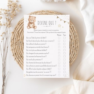 Peut inclure: Une carte de jeu de baby shower avec le texte "DEVINE QUI?" et une illustration d'ours en peluche. La carte présente une liste de questions avec des cases à cocher pour "Maman" et "Papa" pour deviner qui fera quoi. La carte est décorée d'étoiles et de bannières.