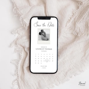 Può includere: Uno smartphone mostra un annuncio di matrimonio. Lo schermo presenta una foto in bianco e nero di una coppia, con il testo "Save the Date" sopra. Sotto, l'annuncio recita "Mariage de Louise et Thomas à Avignon" con un calendario.