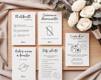 May include: Five white rectangular wedding signage cards with black text and line art illustrations. The cards feature instructions for a photobooth, an unplugged ceremony, a guestbook, a travel-themed sign, and a photo challenge list.