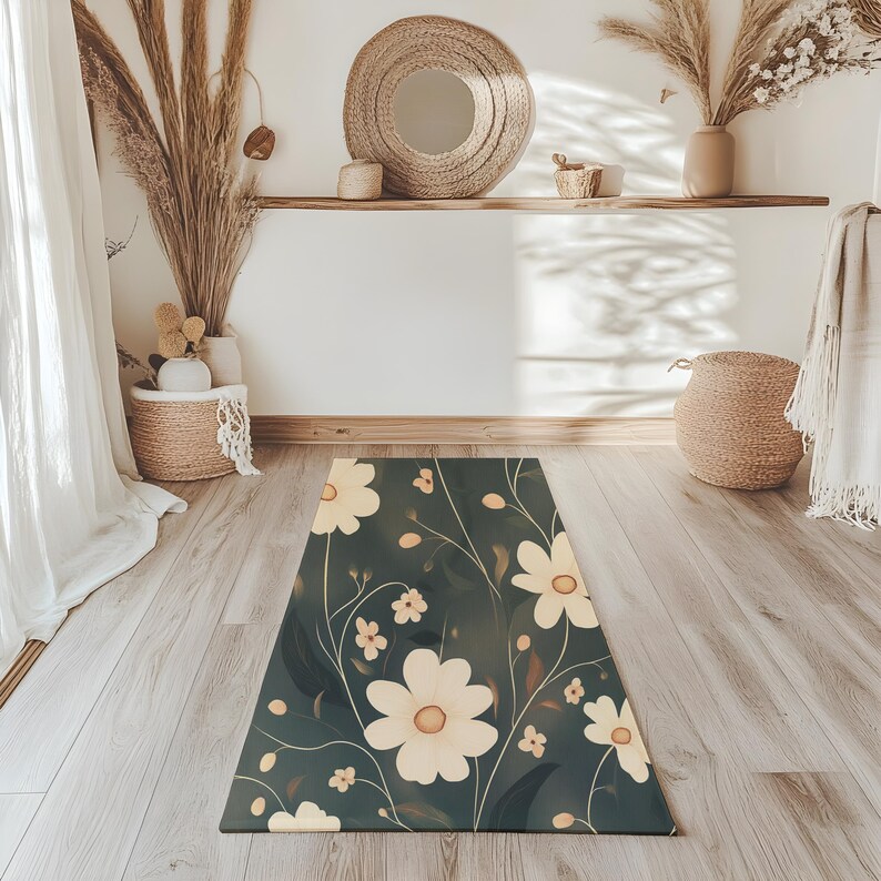May include: A dark green floral rug with white flowers and green leaves. The rug is on a wooden floor in a room with white walls and a mirror.