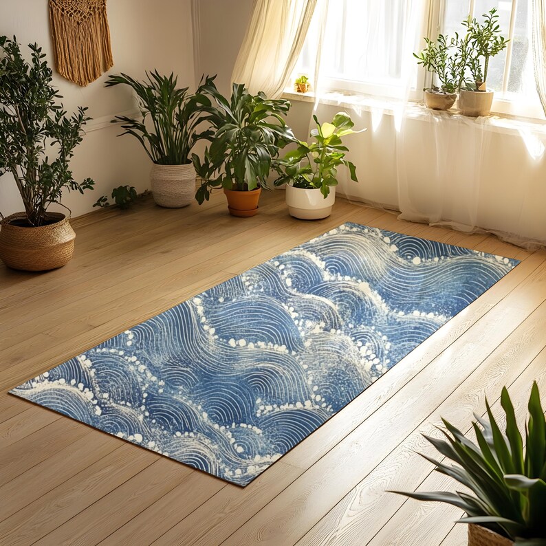 May include: A blue and white area rug with a wave pattern. The rug is on a wooden floor in a room with plants and a window.