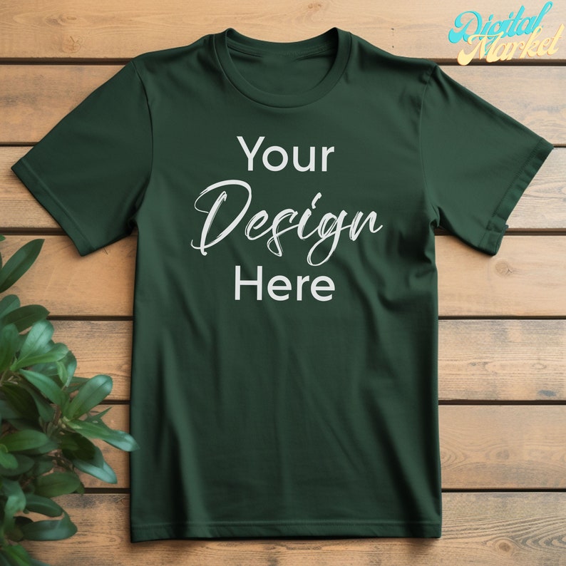Puede incluir: Una camiseta verde oscuro con un dise&ntilde;o blanco que dice "Your Design Here" sobre un fondo de madera.
