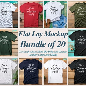 Puede incluir: Un paquete de maquetas de camisetas de cuello redondo en posici&oacute;n plana, que incluye 20 camisetas de diferentes colores, entre ellos blanco, rojo, verde, negro, azul marino y gris jaspeado. Las camisetas est&aacute;n dispuestas sobre una superficie de madera y presentan el texto "Your Design Here" en cada camiseta.