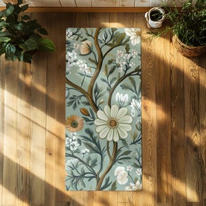 May include: A green yoga mat with a floral pattern featuring white, yellow, and brown flowers. The flowers are arranged in a repeating pattern on a light green background.