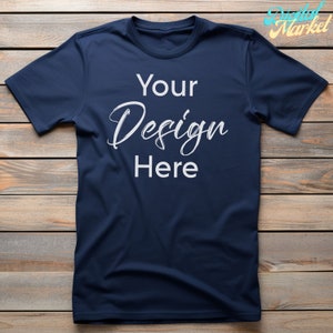 Puede incluir: Una camiseta azul marino con el texto "Your Design Here" impreso en blanco en la parte delantera.
