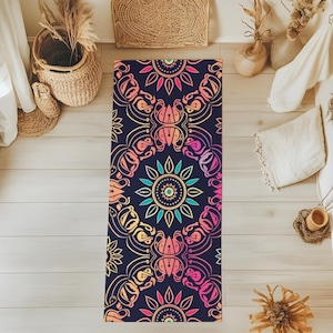 May include: A yoga mat with a colorful mandala design on a dark blue background. The mandala features intricate details and a gradient of pink, orange, yellow, and green.