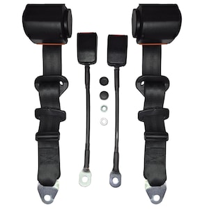 Puede incluir: Dos cinturones de seguridad negros con detalles naranjas y hebillas metálicas. Los cinturones están unidos a dos clips metálicos negros. Hay cuatro botones de plástico negro y dos anillos de metal plateado.