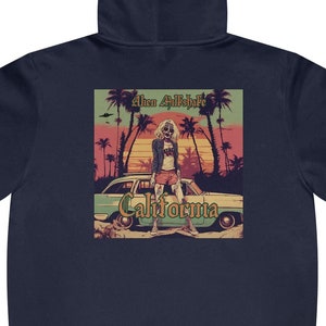 May include: A navy blue hooded sweatshirt with a graphic print of a woman standing next to a vintage car in front of a sunset. The text "Alan Alda's California" is printed on the graphic.