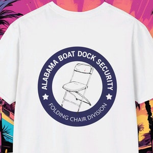 Peut inclure: T-shirt blanc avec un logo circulaire bleu qui dit "Alabama Boat Dock Security Folding Chair Division". Le logo représente une chaise pliante blanche.