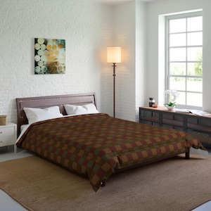 Könnte beinhalten: Ein brauner, grüner und roter karierter Bettbezug auf einem Bett mit weißen Kissen. Das Bett steht in einem Schlafzimmer mit einer weißen Backsteinwand, einer Stehlampe und einem Fenster.